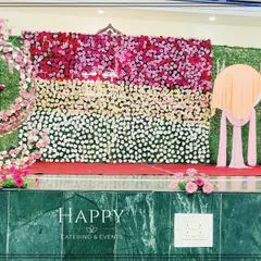 A wide view of a stage with a greenery wall, a floral wall section, and a spiral floral design. This setup offers a variety of textures and colors for a rich visual experience.