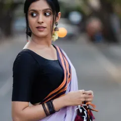 The striking contrast of the orange and red border against the soft lavender makes this Ilkal saree truly special. It's a testament to the weaver's skill in color and design.