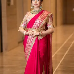 The timeless charm of a red saree. This look is all about royal elegance, featuring soft glam makeup with defined eyes that allows the rich color and intricate work of the saree to take center stage.