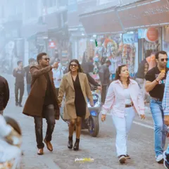A couple walks hand-in-hand through the bustling, foggy streets of Mussoorie, showcasing a natural and unposed pre-wedding moment.
