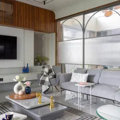 We designed this living room to be both stylish and comfortable. The space features a custom floating TV unit, a plush sectional sofa, and a unique glass partition that separates the area without closing it off, maintaining an open and airy feel.