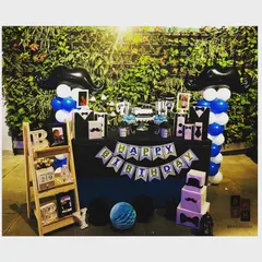The full 'Little Man' themed dessert table and decor for a third birthday party. This setup includes mustache themed balloon columns, custom banners, and a personalized prop shelf.