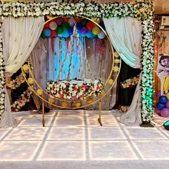 A full view of our Krishna-themed naming ceremony decoration. The central focus is the ornate floral cradle, framed by a beautiful arch and drapes, creating a divine setting for the 'barsa' function.