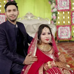 A classic portrait of the couple on the reception stage, seated and looking elegant in their party attire.
