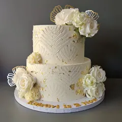 It was all white, gold, and bling for Kairavi's 2nd birthday. This two-tier cake features a beautiful stencil pattern, white roses, and gold leaf accents.