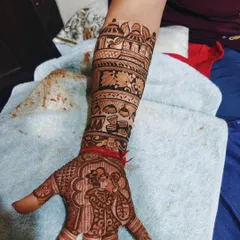 This design captures the moment the groom puts the ring on the bride's finger. The forearm above tells more of the wedding story with a doli scene, symbolizing the bride's journey to her new home.