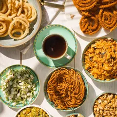 A table full of my homemade snacks is a table full of joy. Here you can see a spread of my offerings, from savory Murukku and Ompudi to sweet Peanut Chikki, all ready for your coffee-time munchies.