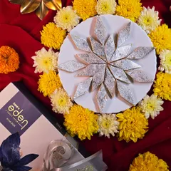 A classic for a reason. My Kaju Katli, arranged here in a festive star pattern, is a timeless gift. It's made with quality cashews and just the right amount of sweetness, complete with silver leaf.