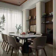 My custom "Hover" dining table features a streamlined marble top that appears to float on its concrete and steel base. It brings an understated grandeur to the room, complemented by the vertical curved storage units I designed to blend into the walls.