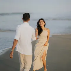 A beautiful candid moment as a couple walks along the water's edge. This "follow me" style shot feels natural and captures a genuine smile.
