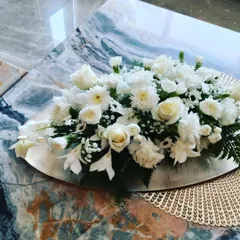 Even simple arrangements can be incredibly elegant. This low centerpiece of white roses and carnations on a silver platter is perfect for home events, dining tables, or as a subtle decorative accent.