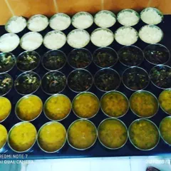 Getting a large order ready for delivery. This shows how we prepare dozens of individual tiffins, with separate containers for rice, dal, and sabzi, ensuring quality and consistency for bulk food orders.