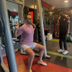 A coach provides verbal cues during a barbell squat. This personalized attention ensures every repetition is safe and effective, helping the client master the movement and build lower body power.