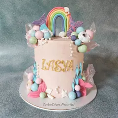 This super tall, 10-inch double-barrel cake combines two popular themes: mermaids and rainbows. It's a whimsical design with colorful chocolate spheres, fondant sea plants, and rice paper sails.
