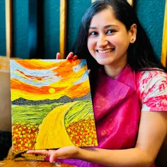 The proud smile of an artist holding her finished textured landscape painting. At our workshops, you'll learn palette knife techniques to create stunning 3D art like this, and you'll walk away with a piece you'll be proud to hang on your wall.
