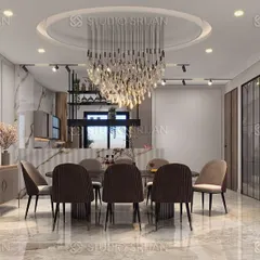 The formal dining area of a Janakpuri residence, where a magnificent crystal chandelier serves as the centerpiece. The space is designed for elegant entertaining, with a large dining table and comfortable upholstered chairs.