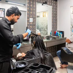 Here, one of my expert team members is applying a treatment in our studio. We provide a full-service experience, from consultation and customization to application and styling.