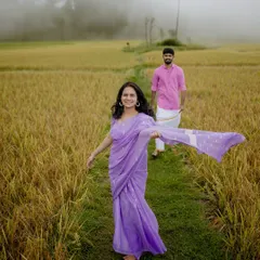 A carefree moment in a misty field. The bride-to-be's flowing saree and happy expression perfectly capture the spirit of a candid photoshoot.