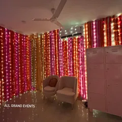 A full view of my popular marigold and fairy light wall decoration. The vertical strings of pink, orange, and yellow flowers mixed with lights create a dense, vibrant backdrop that instantly makes any room feel festive.