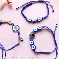 A beautiful trio of my handmade evil eye Rakhis. These feature different designs, including the Hamsa hand and multi-eye patterns, all on adjustable blue braided threads for a comfortable fit.