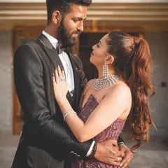 A classic, romantic portrait of the engaged couple. The groom is dressed in a sharp tuxedo and the bride in a gorgeous gown, capturing the elegance of the occasion.