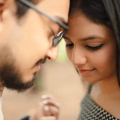 An intimate close-up of the couple with their foreheads together. This tight framing emphasizes their closeness and the quiet, peaceful moment they are sharing.