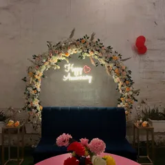 An elegant floral arch with a "Happy Anniversary" neon sign, perfect for a sophisticated celebration. I used pastel-colored flowers and pampas grass to create a soft, romantic photo backdrop.