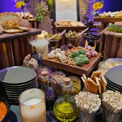 A detailed shot of our grazing table from a Mercedes event. It features a variety of marinated olives, herb-crusted cheese balls, artisanal nuts, and fresh dips, all beautifully arranged for guests to enjoy.