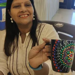 A guest at the Sakhi Ladies Group art party, beaming with pride as she shows off her colorful dot mandala mug. Each person's design is unique, reflecting their own creative spirit.
