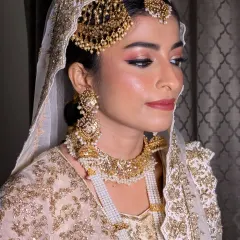 Creating this soft and regal Nikkah look for Afrin was a dream. The makeup features subtle pink tones on the eyes and lips to complement her ivory and gold outfit, letting her Nizami jewellery, including the elegant passa, take center stage.