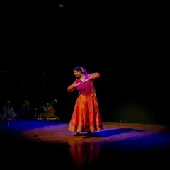 A powerful pose under the spotlight during a solo performance. The dramatic lighting emphasizes the expressive storytelling ('abhinaya') that is a core component of my Jaipur Gharana training.