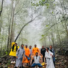 Our energetic group posing mid-trek in a misty forest path in Kurinjal. The raincoats and smiles say it all about the spirit of our monsoon adventures.