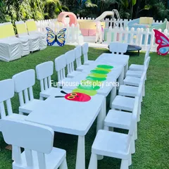 This outdoor setup features our white tables and chairs decorated for a "Very Hungry Caterpillar" theme. In the background, you can see our pastel soft play area enclosed by a white picket fence, ensuring a safe and coordinated play space.
