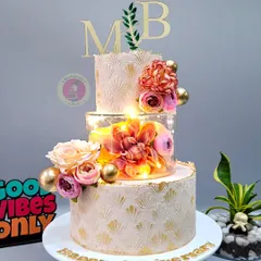 Elegance is an art form. This three-tiered anniversary cake, with its delicate stenciling, soft florals, and glowing lights, shows that beauty is in the details. I teach how to create these premium finishes that allow you to command higher prices for your work.