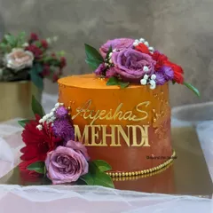 I love how the vibrant orange hues turned out on this Mehendi cake for Ayesha. The rich color is complemented by a gold name topper and a beautiful arrangement of fresh purple and red flowers.