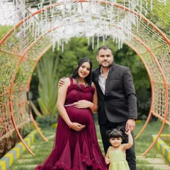 A complete family portrait in a whimsical, fairy-light tunnel. This image captures the magic of the moment, with the whole family dressed up to celebrate the new arrival.