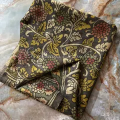 A folded view of the charcoal grey silk dupatta, focusing on the dense and intricate floral pattern that covers the fabric. This is a hallmark of traditional Srikalahasti art.