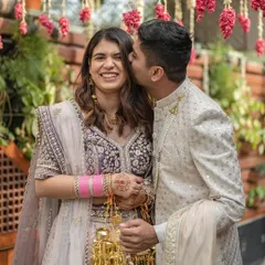 A sweet kiss on the cheek during an intimate Delhi wedding. This photo captures a tender moment between the couple amidst the celebration, showcasing their affection and happiness.