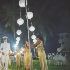 Bridesmaids in elegant gold dresses light the way with sparklers for the couple's entrance. This shot captures the warmth and support of friends on the wedding day.