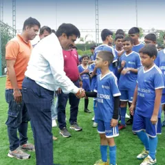 A special guest shakes hands with one of our young players at the Pune launch, welcoming him to the FSI family.
