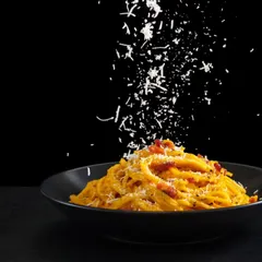A classic Italian pasta dish, elegantly plated and finished with a generous shower of parmesan cheese. We're here to elevate your special occasions with top-tier catering and authentic global flavors.