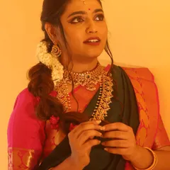 This hairstyle features a loose, textured side braid with fresh jasmine flowers woven in. It's a beautiful fusion of modern and traditional, perfect for a pre-wedding event.