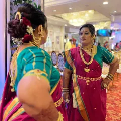A candid mirror shot showing the complete traditional look. The kamarbandh (waist belt) and layered necklaces create an authentic and regal silhouette.