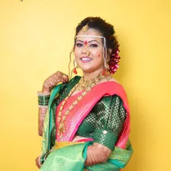 Our beautiful bride in her vibrant 'Marathi Saaj'. We used a color palette that complements her pink and green saree, ensuring she looks bright and festive for her special day.