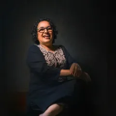 Laughter is a beautiful expression of the soul. This portrait captures a moment of pure, uninhibited joy, with the lighting focused on her happy face, creating an intimate and heartwarming image.