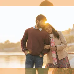 The perfect golden hour glow. The setting sun creates a beautiful flare as the couple shares a warm, cozy moment by the river, showcasing the magical light we love to shoot in.