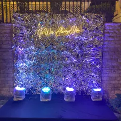 A modern and romantic photo booth perfect for a sangeet or engagement party. The combination of a crinkled silver foil backdrop and a warm neon sign creates a cool, edgy, and intimate vibe.