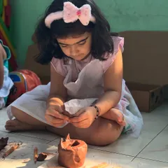 Deep in concentration, this little artist is shaping her terracotta clay creation. Clay modeling is a fantastic activity for developing focus and patience, allowing children to get lost in the creative process.