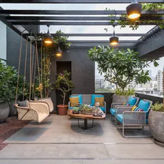 We create sophisticated rooftop escapes designed for comfort and style. This terrace features a dark-toned pergola that provides partial shade, complemented by a comfortable seating area, a hanging swing, and large planters that add a touch of nature.