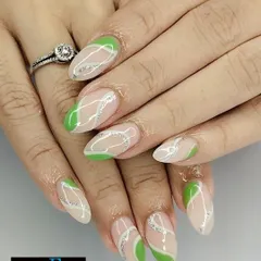 This abstract design uses negative space for a modern feel. We combined bright green color blocks with swirling, fine lines of silver glitter on almond-shaped nails.